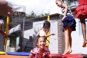 Crianças brincam felizes na Grota do Aterro; o jovem João Paulo e dona Leila com duas crianças foram devidamente atendidos com os serviços ofertados com o Governo Presente neste sábado (18) na comunidade do Novo Mundo.