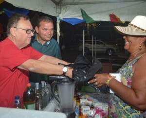 Prefeito Isnaldo Bulhões (camisa vermelha) cumprimenta vendedora durante o carnaval santanense
