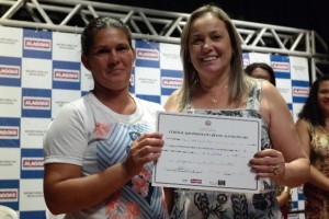 Superintendente Wilany Felix (direita) entrega certificado a alfabetizando